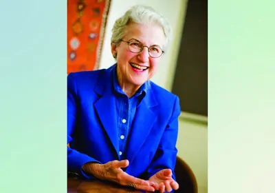 Photo of older woman dressed in blue smiling and looking at the camera Photo of older woman dressed in blue smiling and looking at the camera
